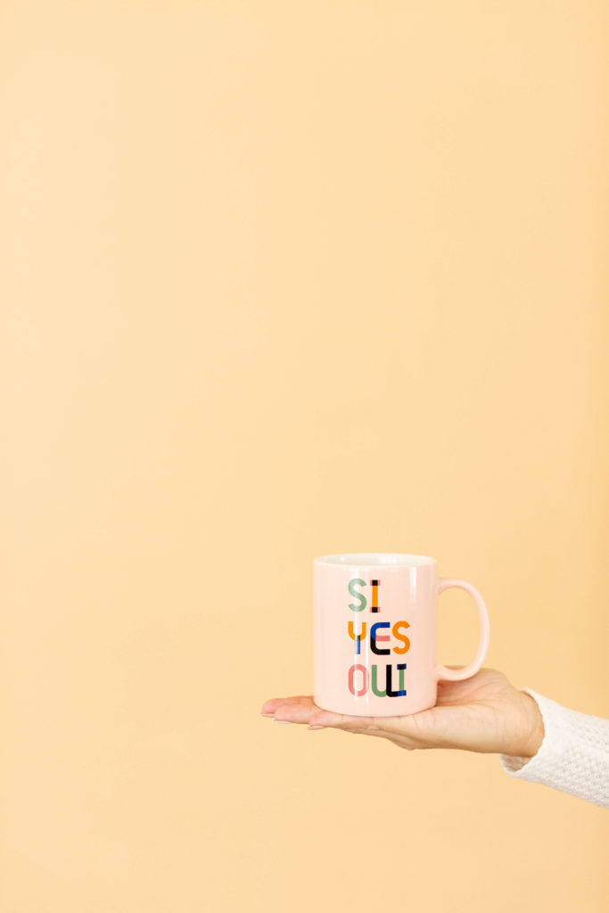 A cute mug that reads, "Si, Yes, Oui" it is time to do an annoyance in your biz and get more s#%t done with ease from LA based clarity coach Tabitha Abercrombie